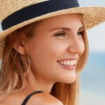 Adorable Young Woman Wears Straw Hat, Sits On Desert Seashore Aluser of Xeomin